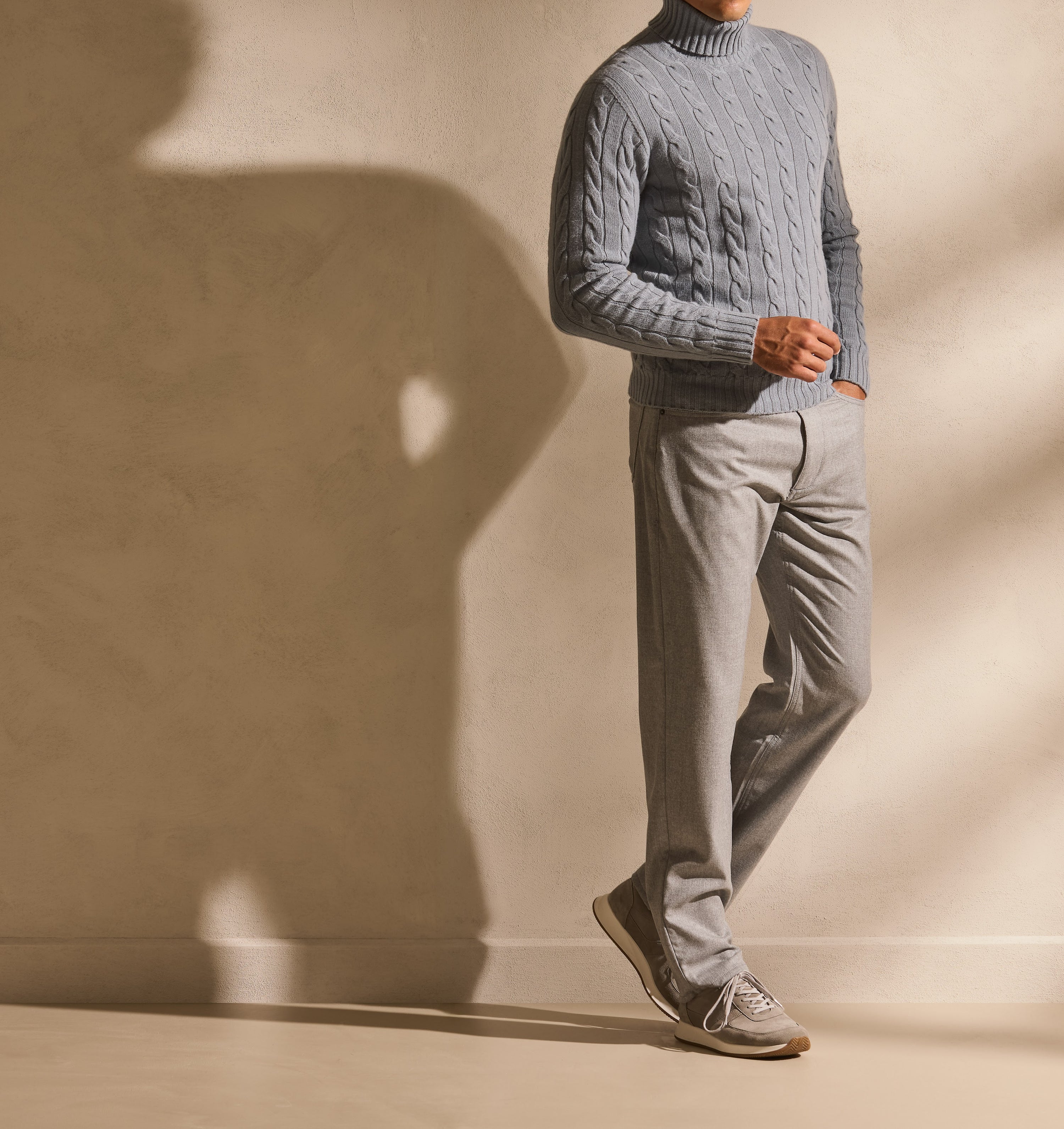 Pulover cable-knit într-un total look luminos — textura devine punctul de interes.