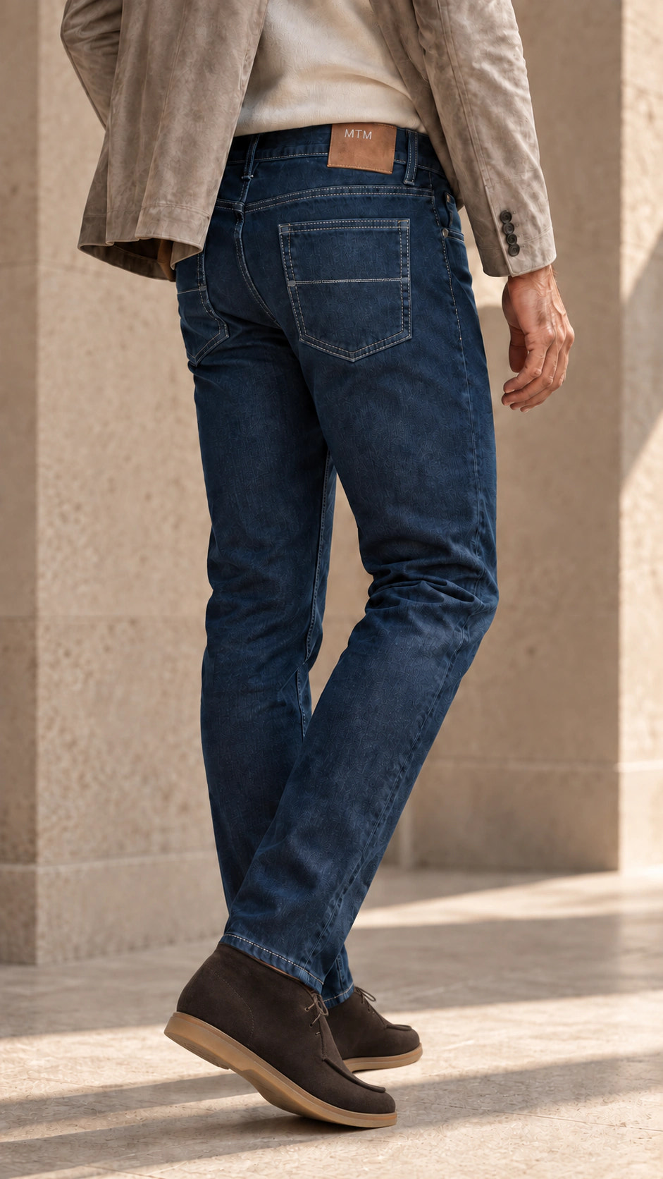 Vedere din spate a ținutei cu denim indigo și sacou grej.