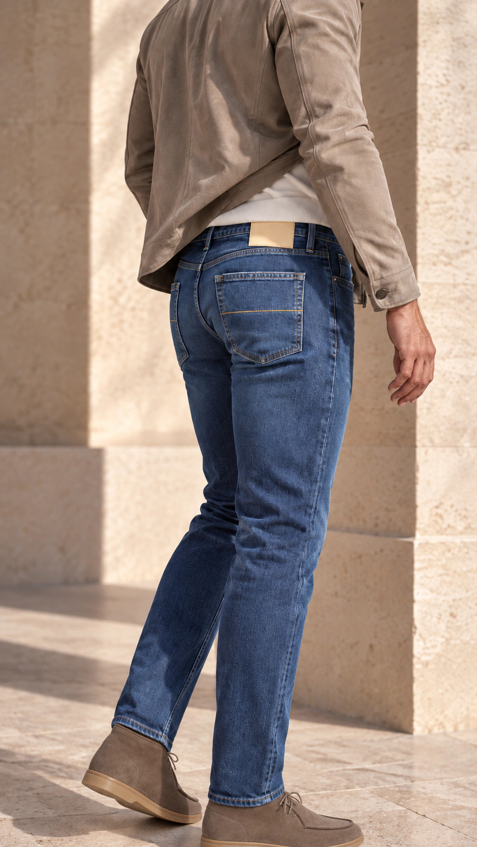Vedere din spate a ținutei cu denim albastru luminos și jachetă taupe.