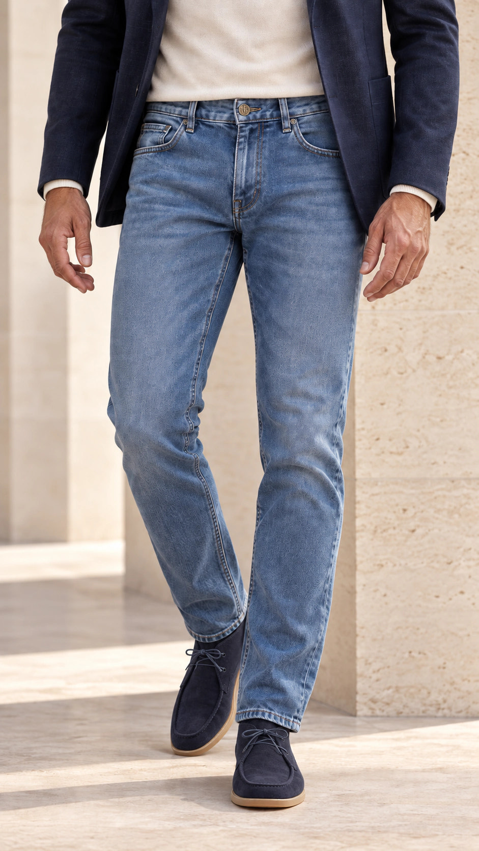 Vedere apropiată din față a ținutei cu denim prespălat și sacou navy.