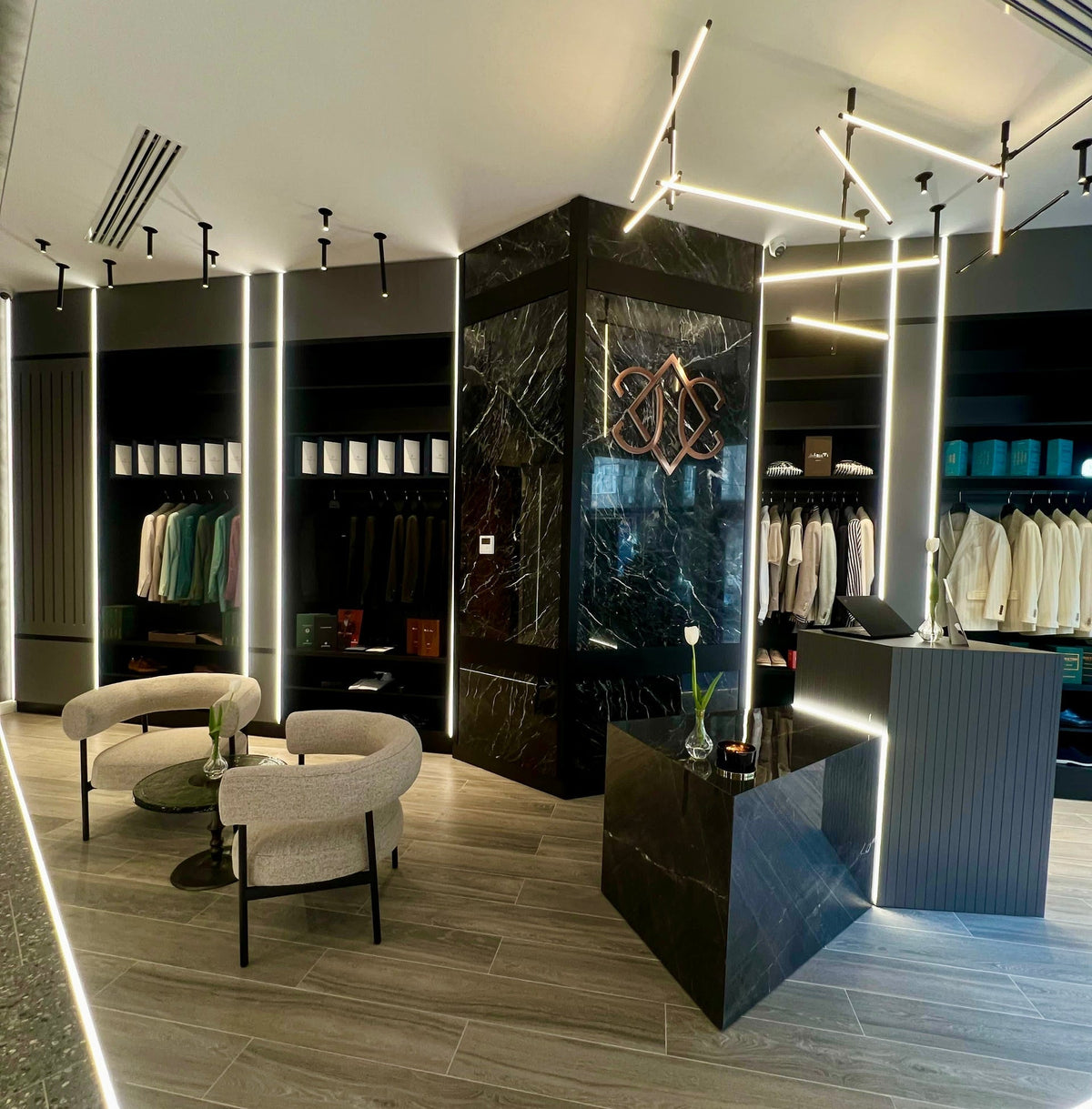 Monograma Consiglieri pe un panou închis, cu fotolii deschise și ținute expuse în showroom
