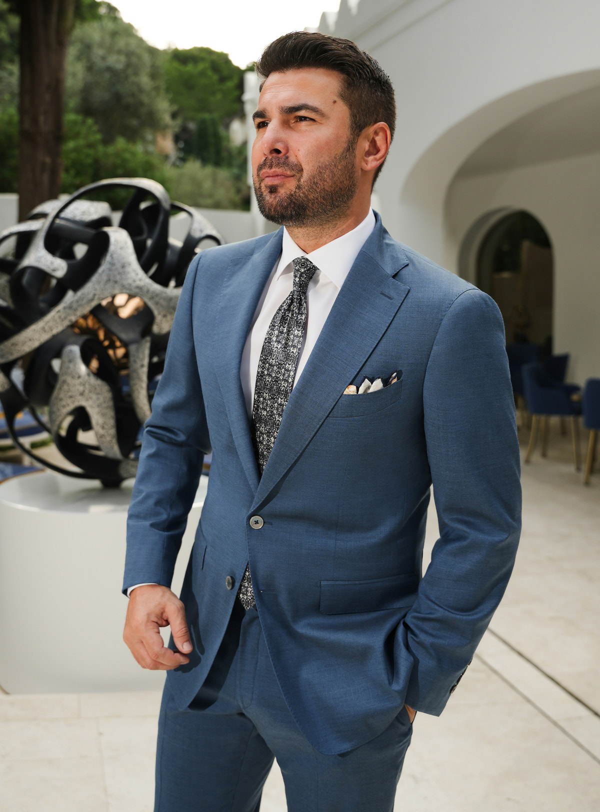 Costum albastru prăfuit Consiglieri, cu rever crestat, cămașă albă și cravată cu model