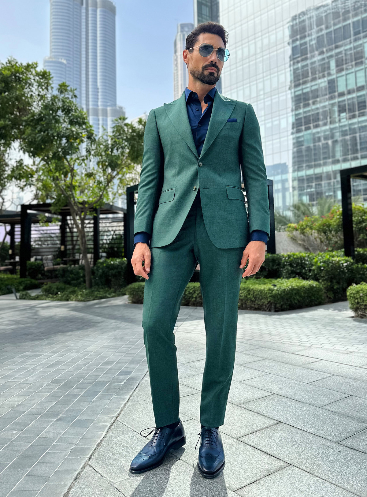 Costum Prestige Charisma Consiglieri verde cu cămașă bleumarin, într-un cadru urban