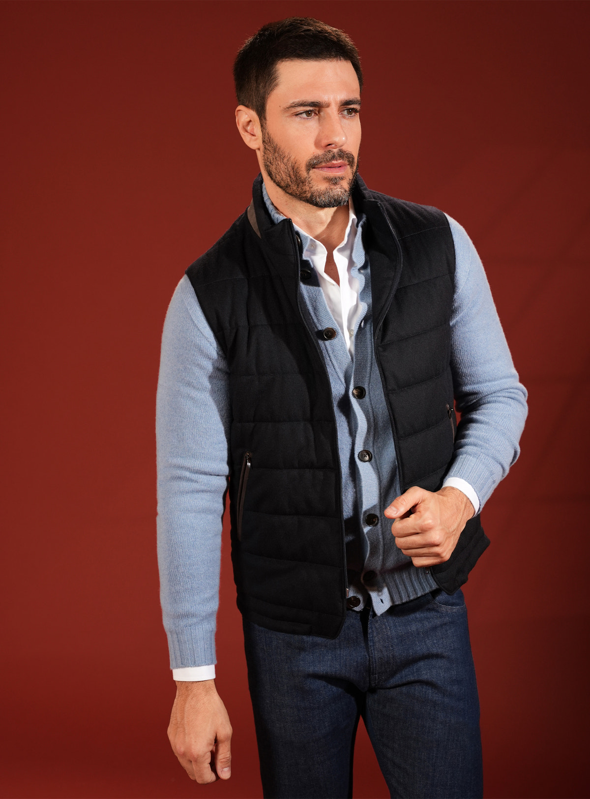Vestă matlasată neagră Consiglieri, purtată peste un cardigan bleu