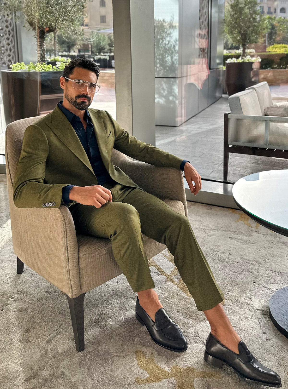 Costum verde măsliniu Consiglieri, într-o ținută relaxată, așezată în salon