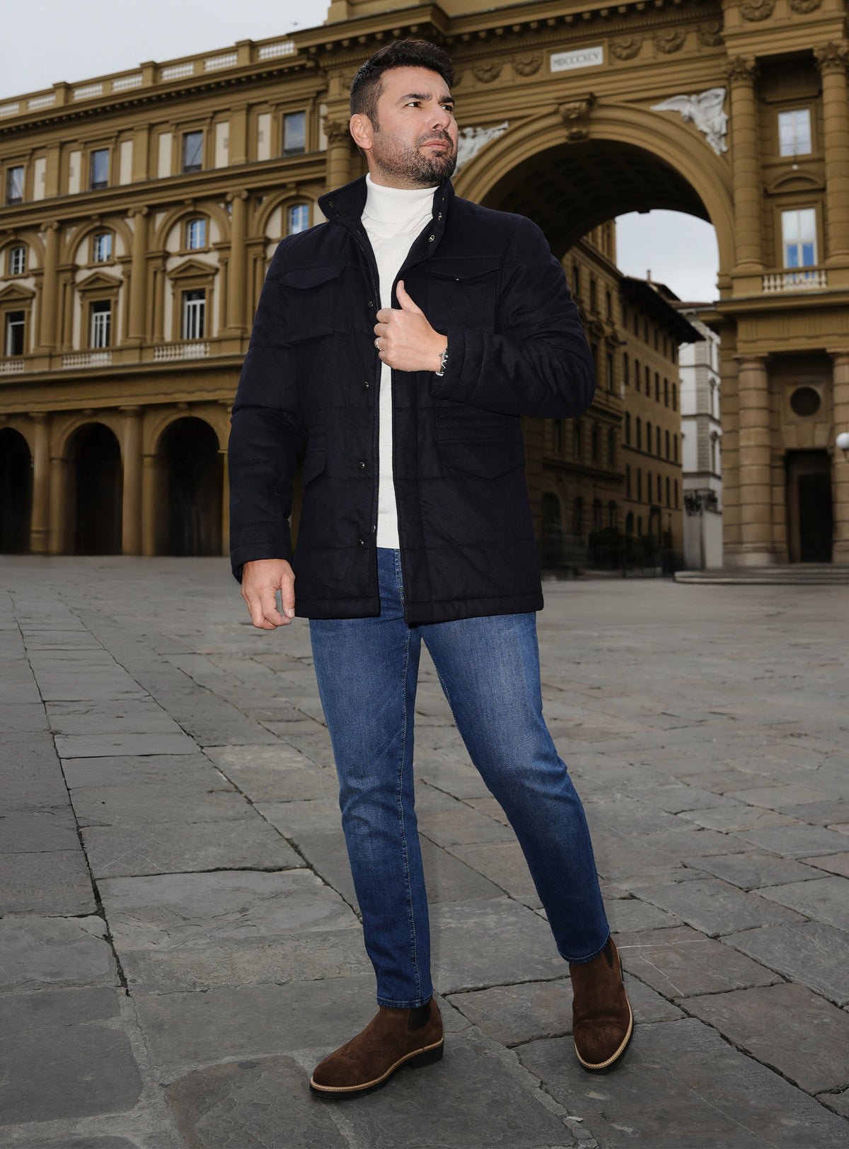 Jachetă bleumarin Consiglieri, purtată cu maletă albă și jeans albaștri