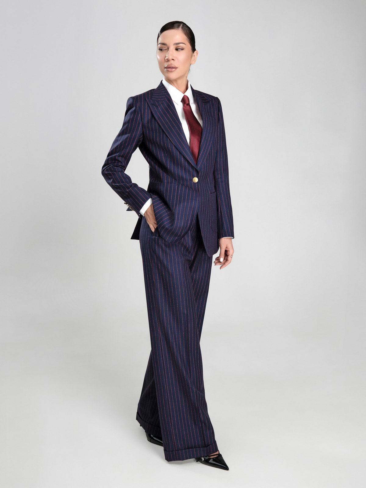 Costum de damă bleumarin Consiglieri DONNA cu dungi fine, purtat cu cămașă albă și cravată bordo