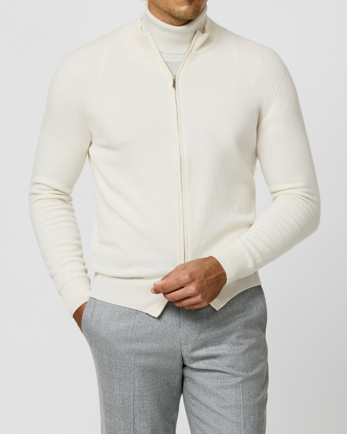 Cardigan crem Consiglieri cu fermoar și guler înalt, purtat cu pantaloni gri