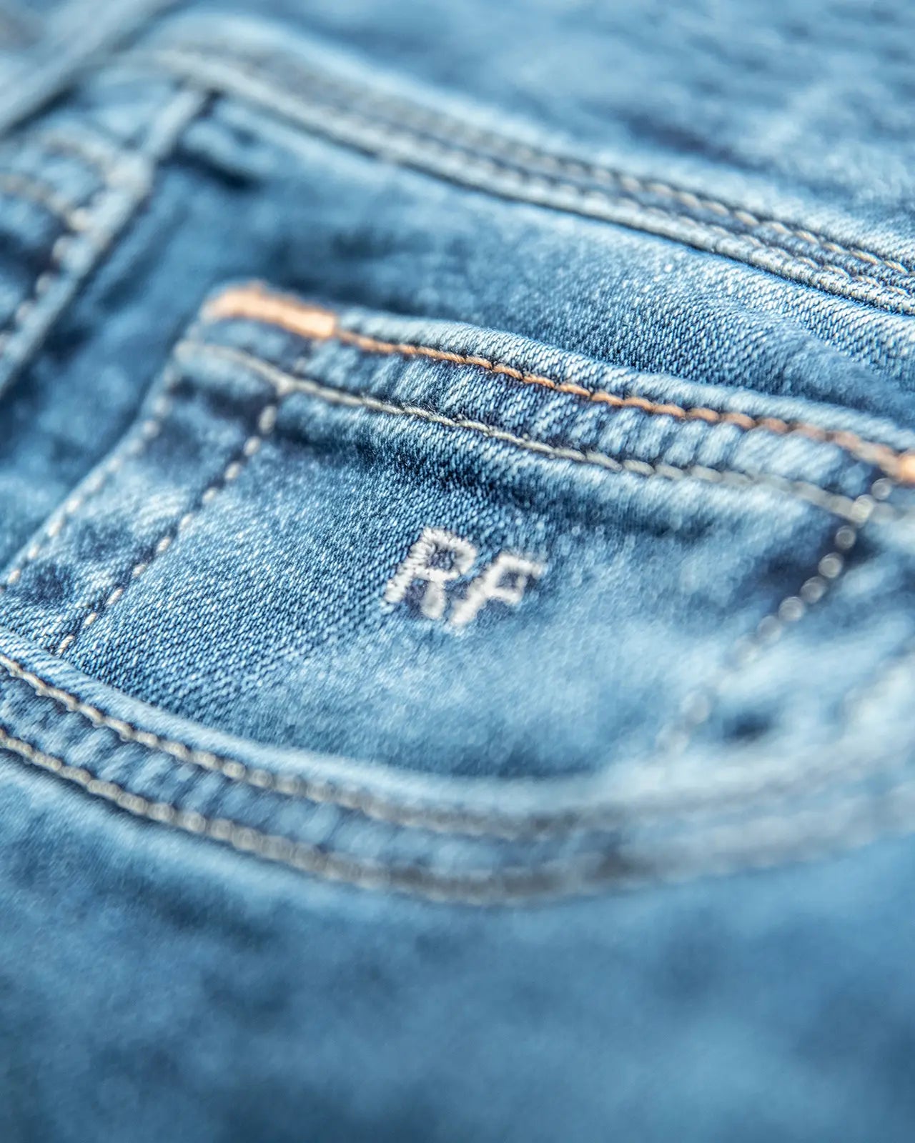 Inițiale personalizate, aplicate discret — semnătura unei perechi Custom Made Jeans.