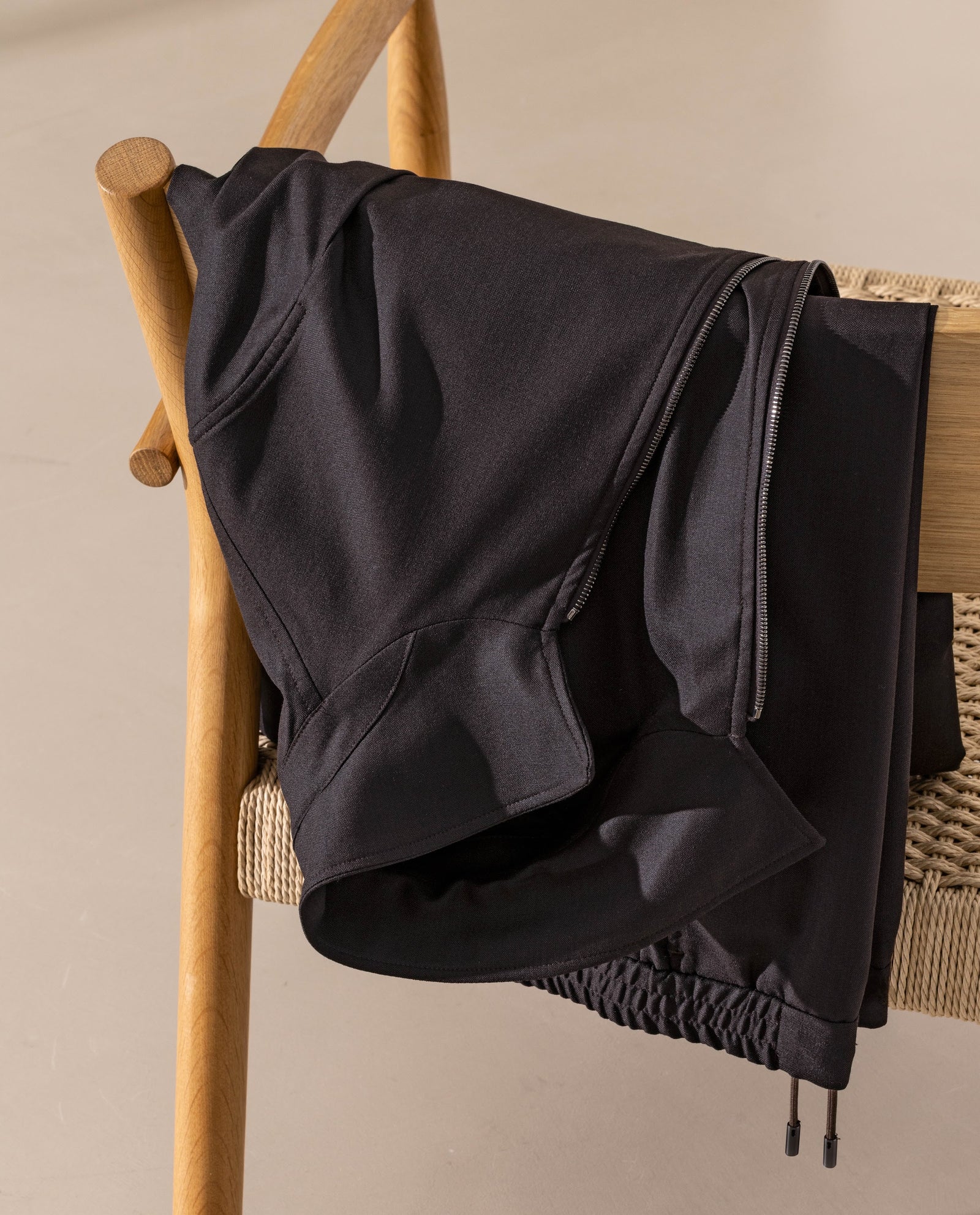 Textura fină și fermoarul discret ale The Track Suit Consiglieri, într-o interpretare Luxury Leisurewear.