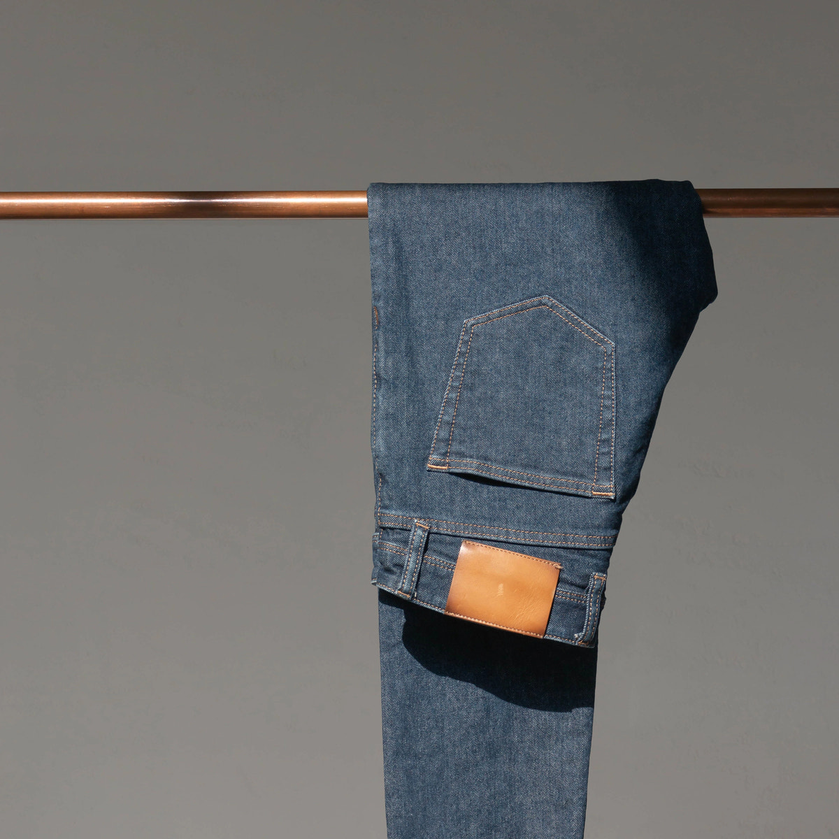 Denim indigo profund, buzunar și cusături tabac — detaliu Custom Made Jeans.
