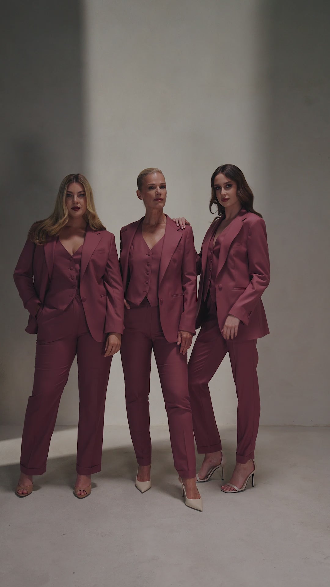 Trei femei în costume vișinii The Vendôme Suit Consiglieri, cu sacou și vestă