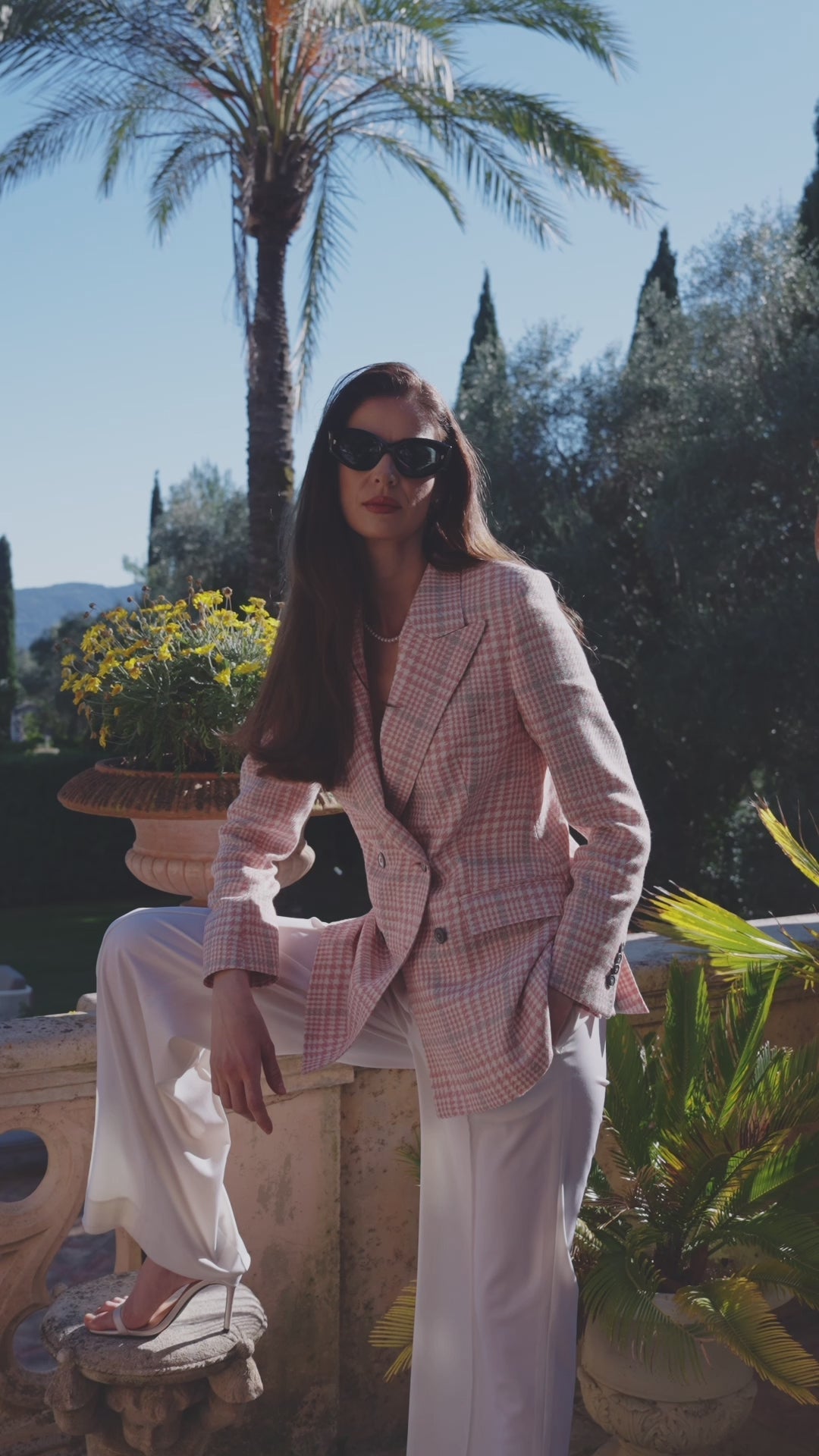 Sacou feminin roz pal cu pantaloni ivoire, purtat pe o terasă însorită
