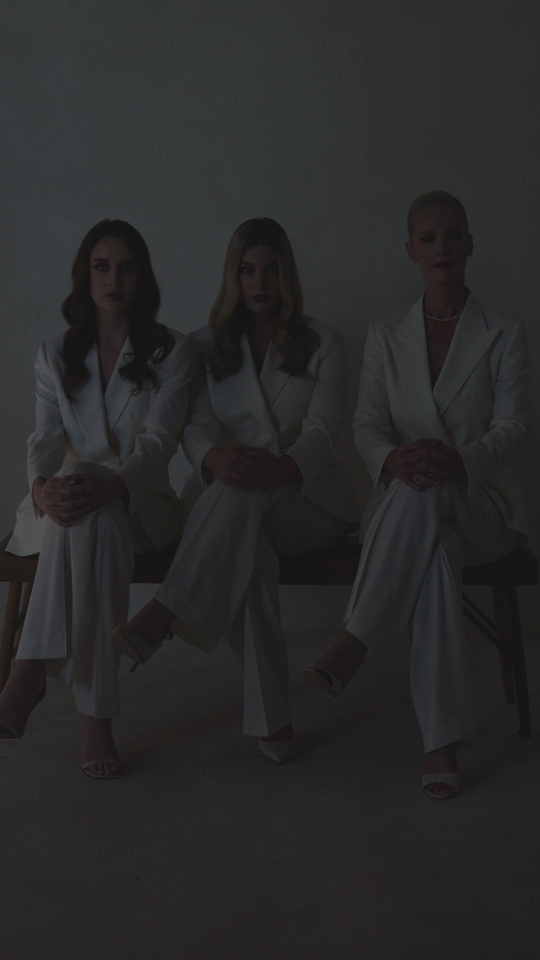 Trei femei în costume ivoire The Riviera Suit Consiglieri, așezate împreună