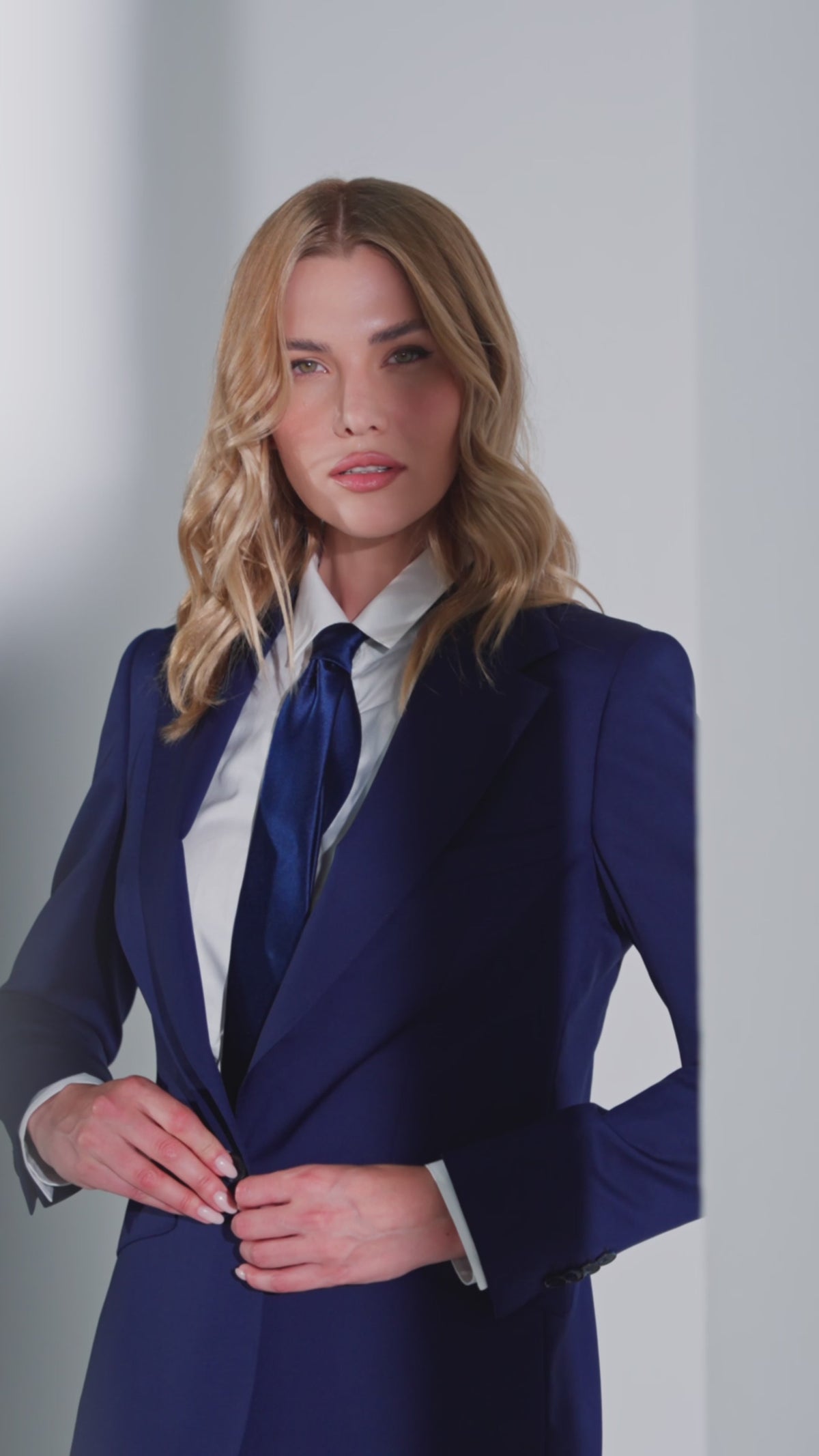 Sacou feminin bleumarin, cu cămașă albă și cravată închisă la culoare