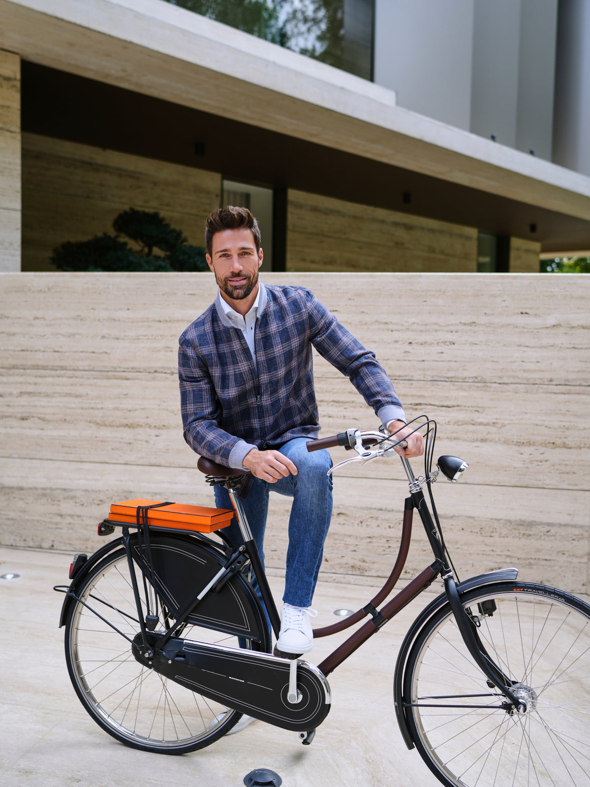 Jachetă Cessena Privé Consiglieri în carouri albastre și maro, purtată cu jeans lângă o bicicletă