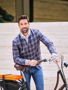 Jachetă Cessena Privé Consiglieri în carouri albastre și maro, purtată cu jeans lângă o bicicletă