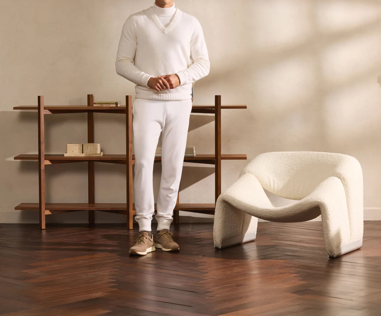 Maletă albă purtată cu pantaloni albi și pantofi taupe